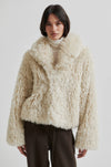 Person wearing a fluffy beige jacket on a white background