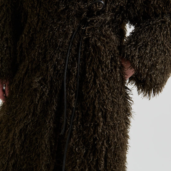 Close-up of a brown textured coat with a blurred background