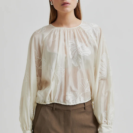 round neck ecru blouse with tonal floral print with long cuffed sleeves model shot