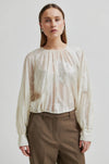 round neck ecru blouse with tonal floral print with long cuffed sleeves model shot