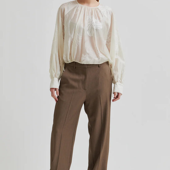 round neck ecru blouse with tonal floral print with long cuffed sleeves model shot