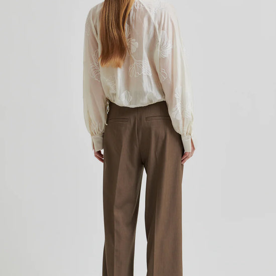 round neck ecru blouse with tonal floral print with long cuffed sleeves rear view