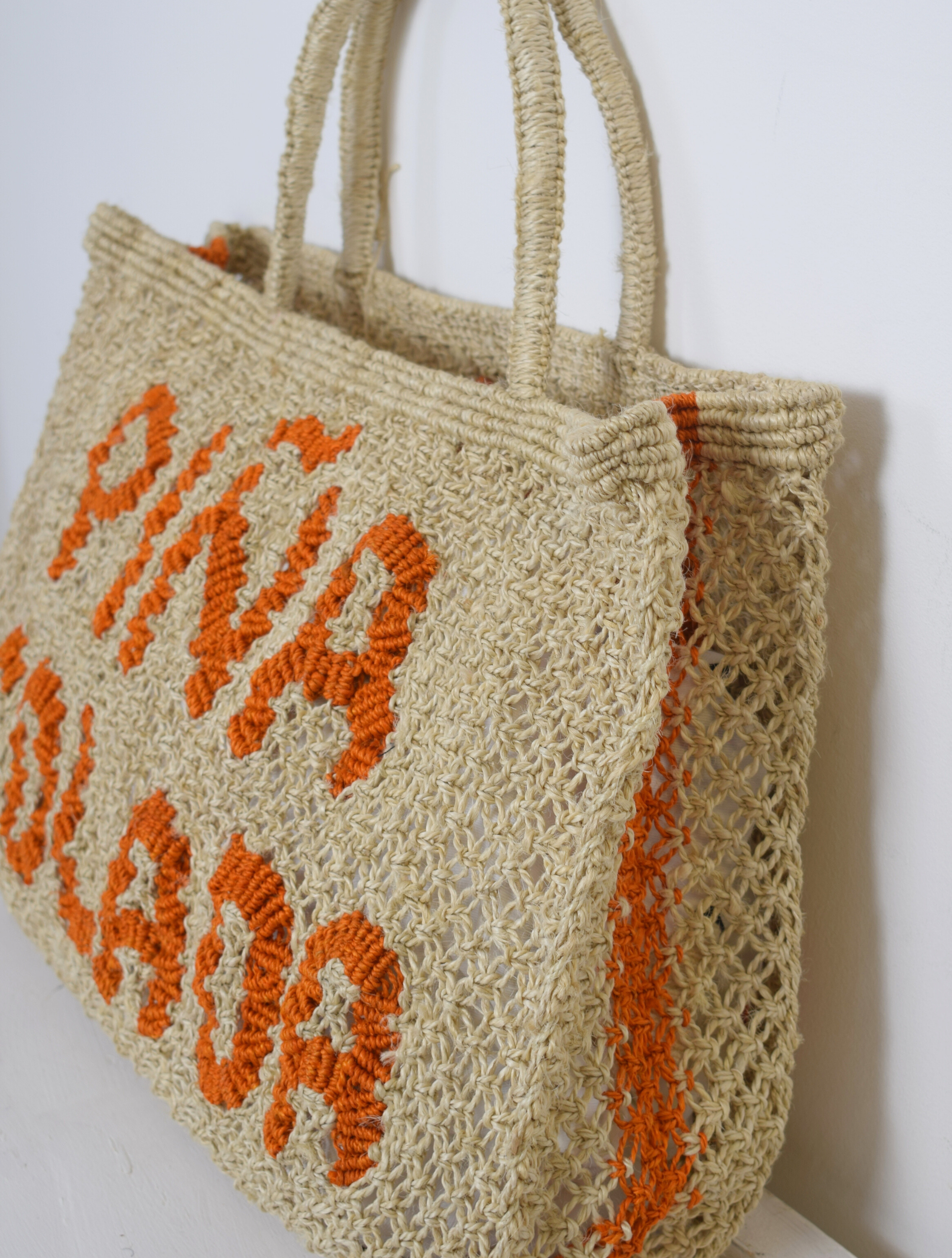 Woven nautral bag with pina colada writen on it in orange