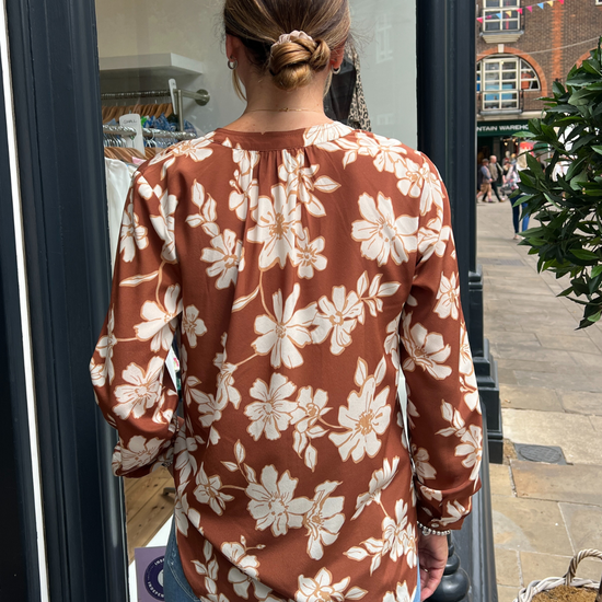 A tan top with white flowers 