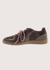 A low-top sneaker in dark brown suede and canvas with dusty pink laces and a tan gum sole, shown from a side profile on a light gray background.