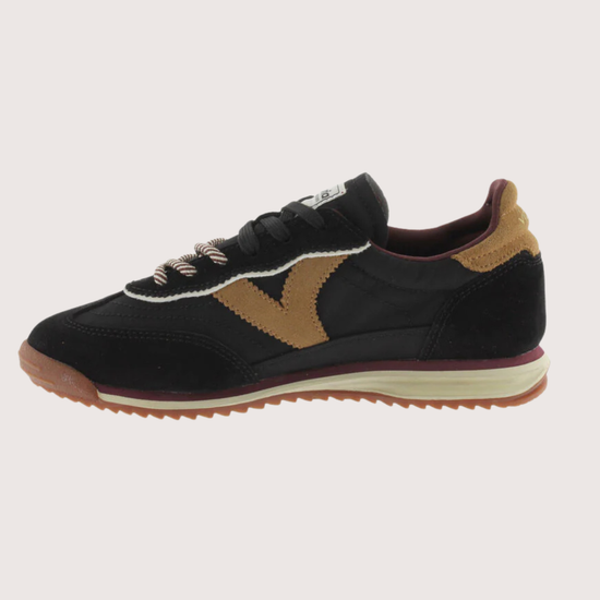 A black suede and mesh low-top sneaker with tan side panels, burgundy lining, and a cream midsole, shown from a side profile on a light gray background.