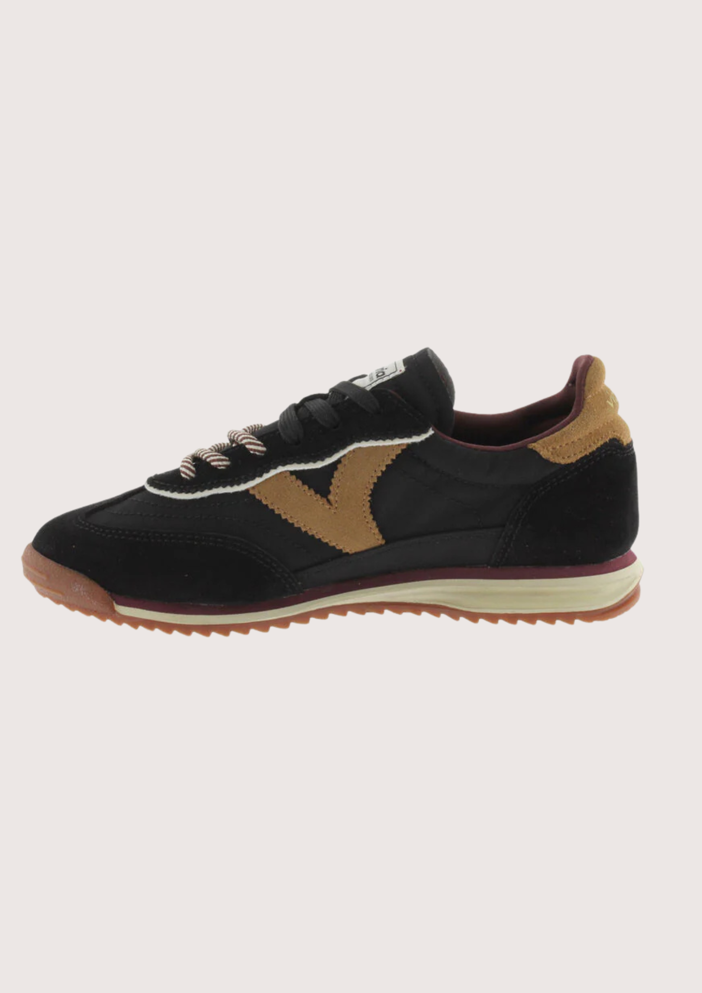 A black suede and mesh low-top sneaker with tan side panels, burgundy lining, and a cream midsole, shown from a side profile on a light gray background.