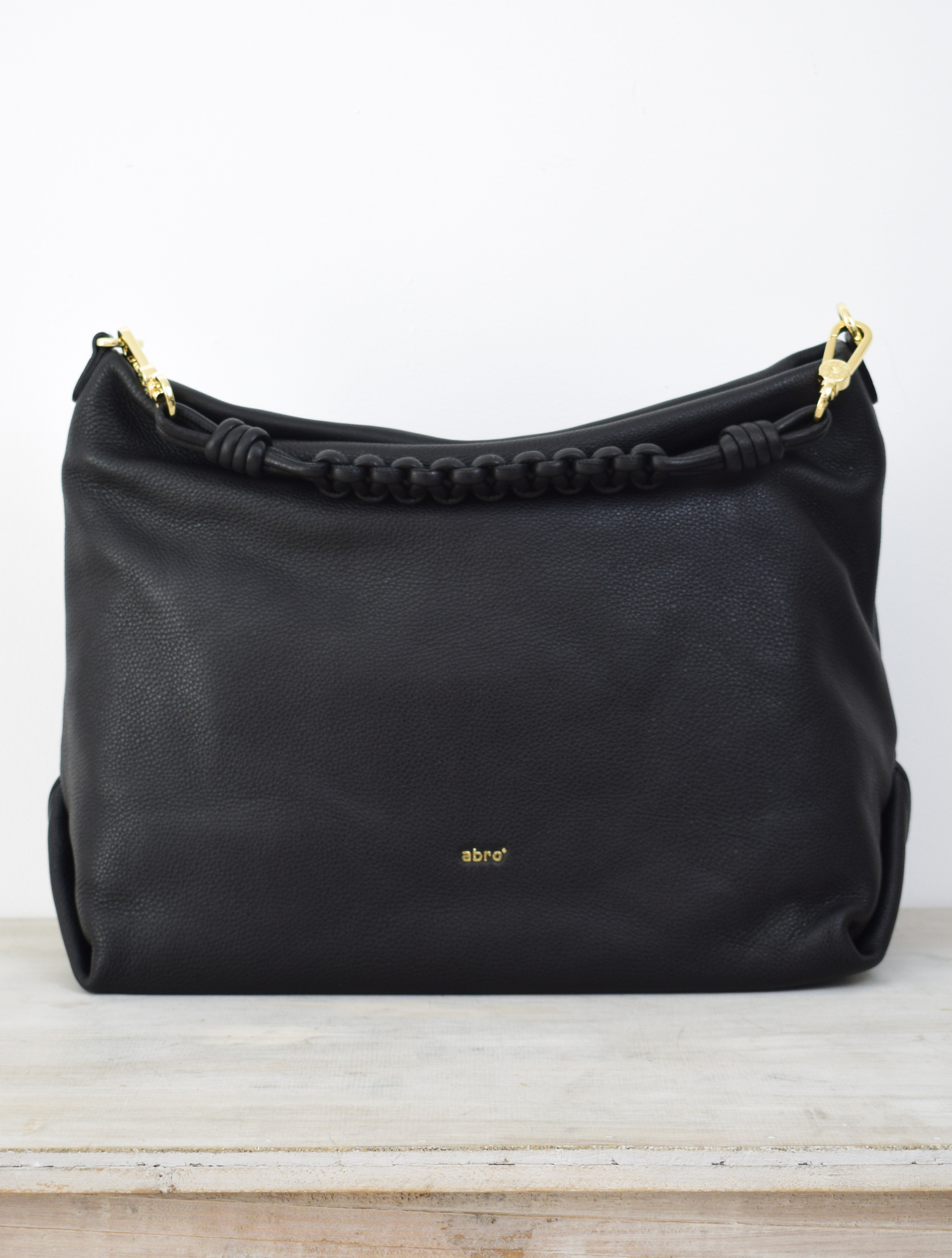 Italian black leather bag with a woven shoulder strap and cross body strap with gold toned hardwear