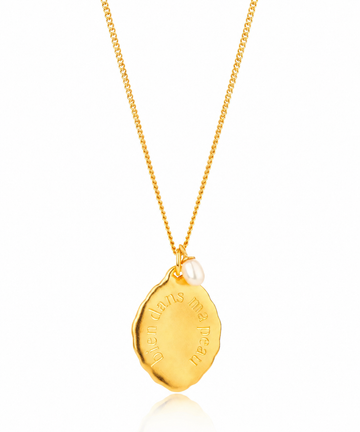close up of a gold pendant necklace 