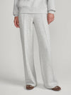 A person wearing light heather gray wide-leg sweatpants with a matching sweatshirt partially visible, standing against a plain light gray studio background.