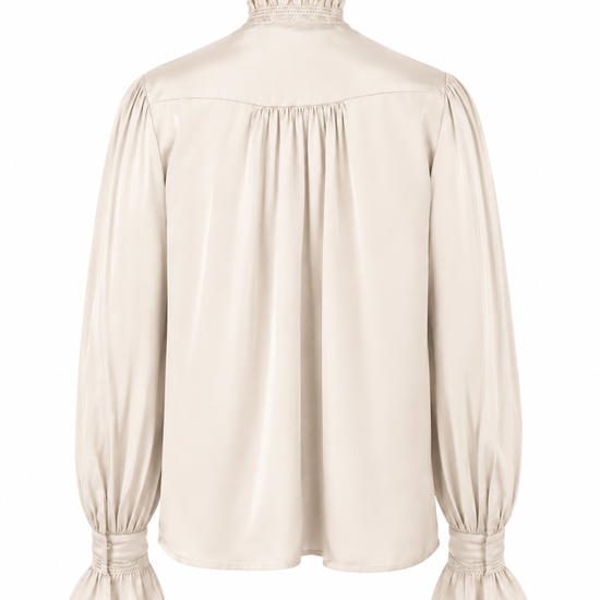 A cream-colored long-sleeve blouse with a ruffled mock neck, gathered waist, and flared cuffs, shown against a plain white background.