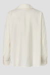 An off-white long-sleeve shirt shown from the back, featuring a relaxed fit and a subtle textured fabric, set against a solid light gray background.