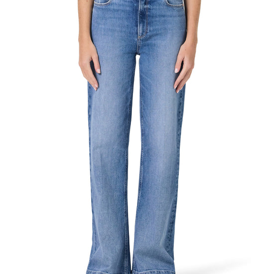 Blue jeans worn by a person on a white background