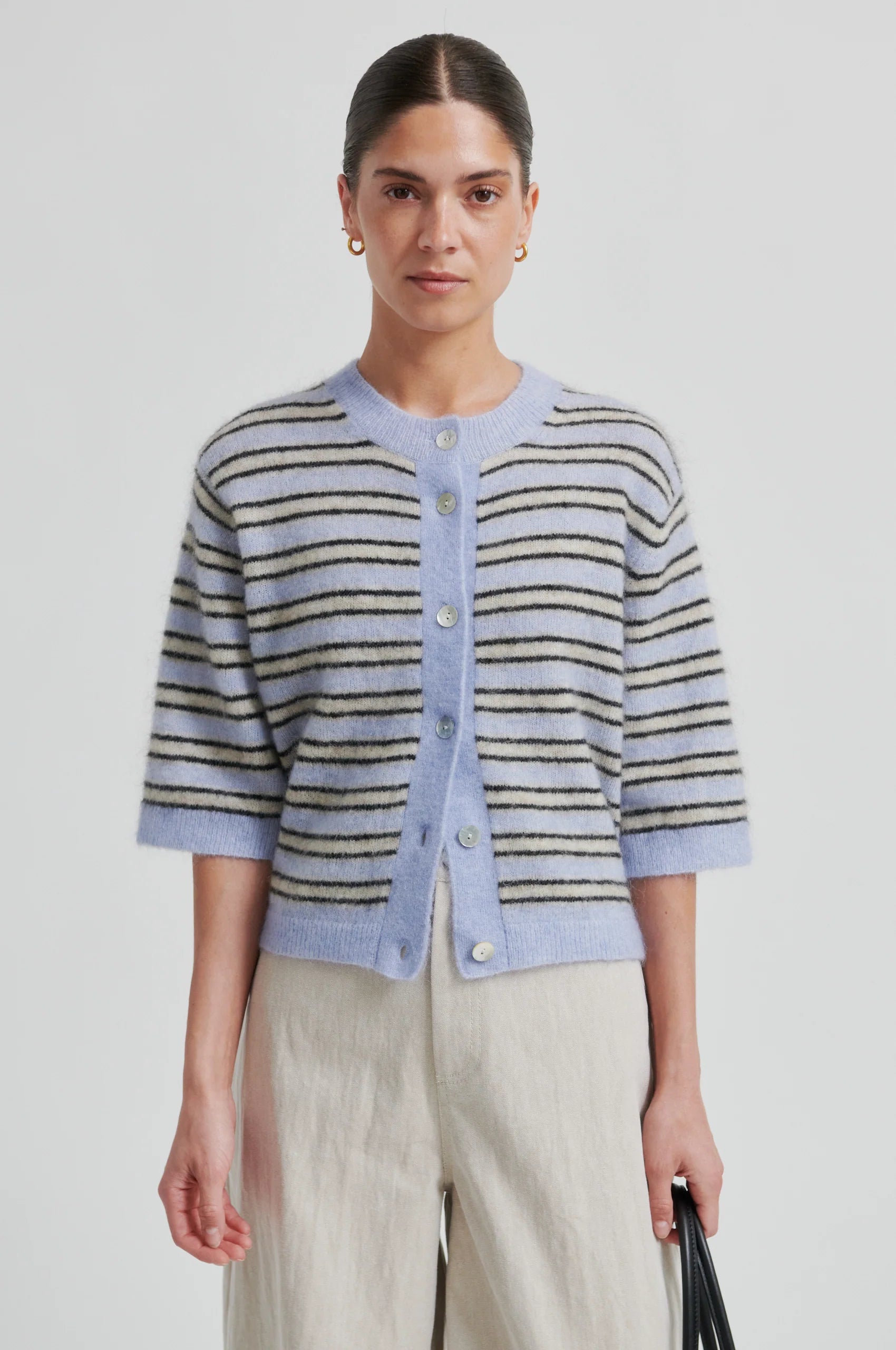 Woman wearing a striped cardigan with a plain background from Second Female