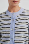 Close-up of a person wearing a light blue and black striped sweater with buttons from Second Female
