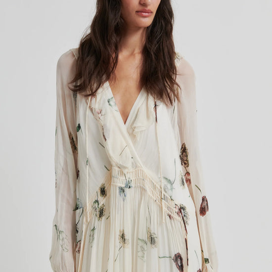 Woman wearing a floral dress with sheer sleeves on a white background from Second Female