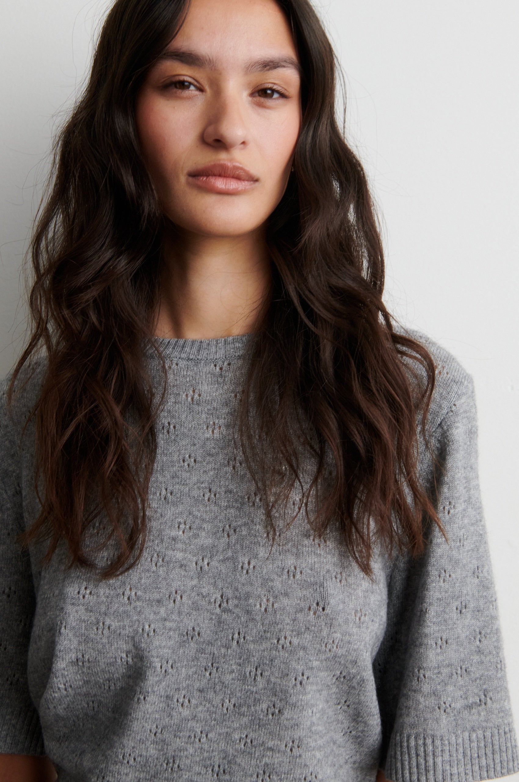 Woman wearing a gray sweater against a plain background from Second Female 
