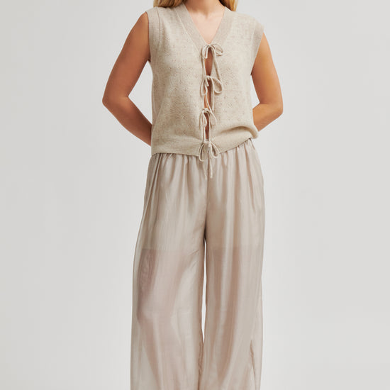 Woman wearing a beige sleeveless top and wide-leg pants on a white background from Second Female