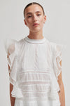 model wearing white frill top on plain background