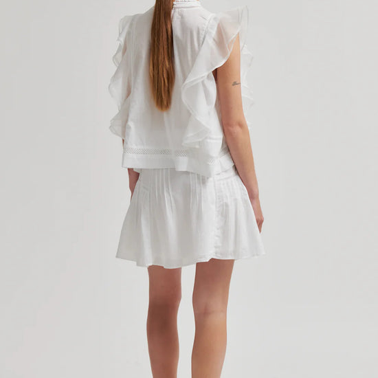 Woman wearing a white outfit on a plain background