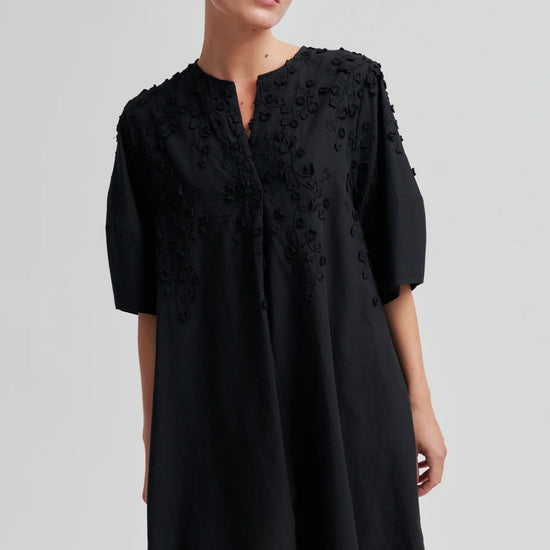 Black dress with applique flowers on a model another angle