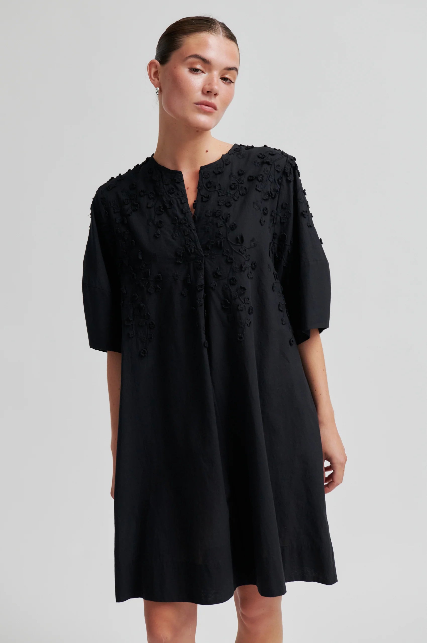 Black dress with applique flowers on a model another angle