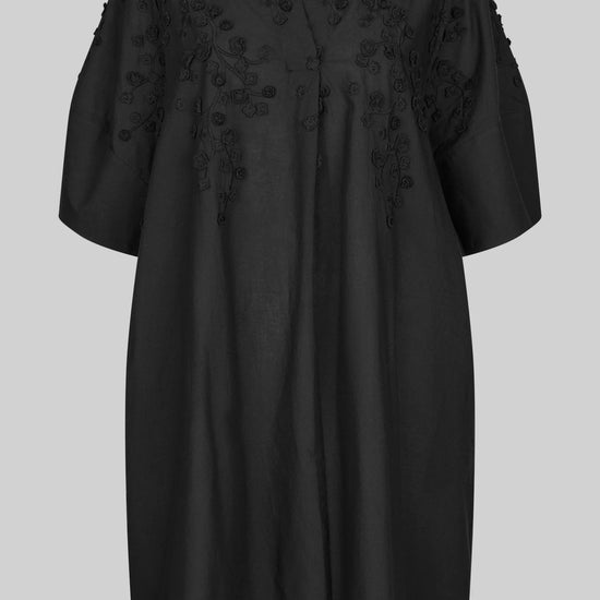 Black dress with applique flowers on a white background