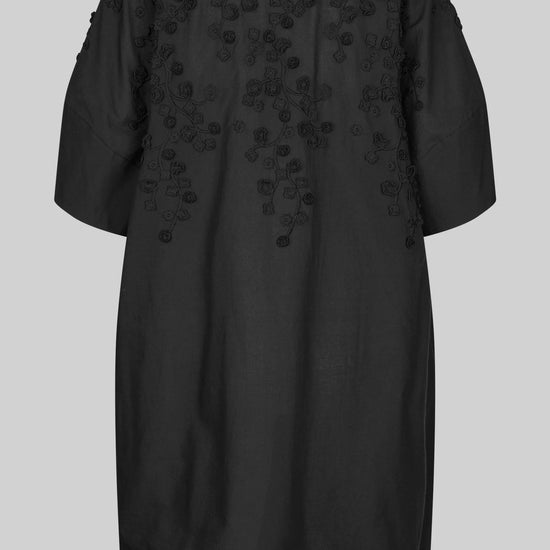 Black dress with applique flowers on a white background rear view