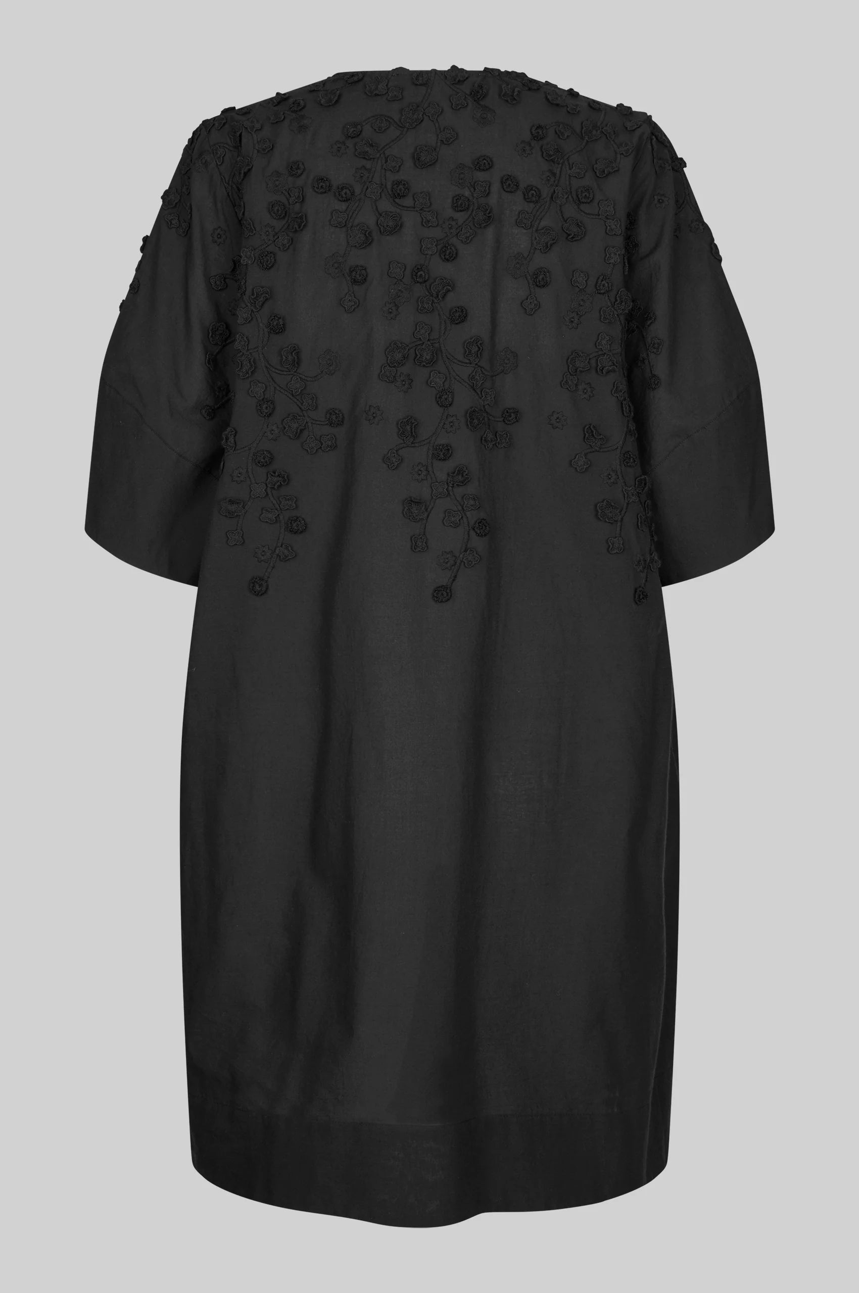 Black dress with applique flowers on a white background rear view