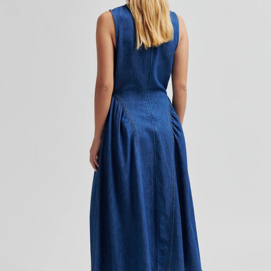 Blue denim dress by second female on a woman rear view