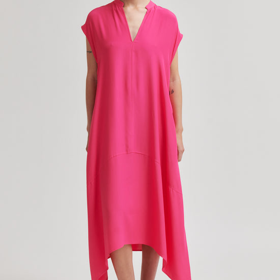 Woman wearing a bright pink dress on a plain background from Second Female