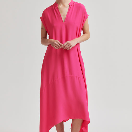 Woman wearing a bright pink dress on a plain background from Second Female