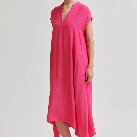 Woman wearing a bright pink dress on a white background