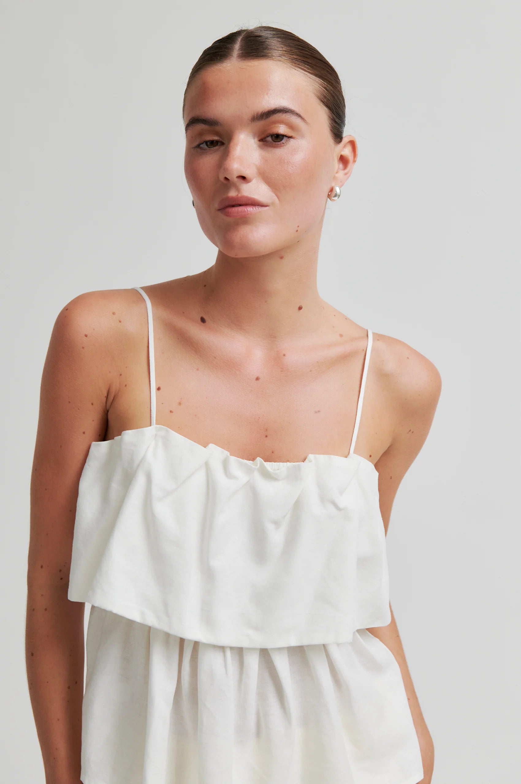 Woman wearing a white dress against a plain background from Second Female