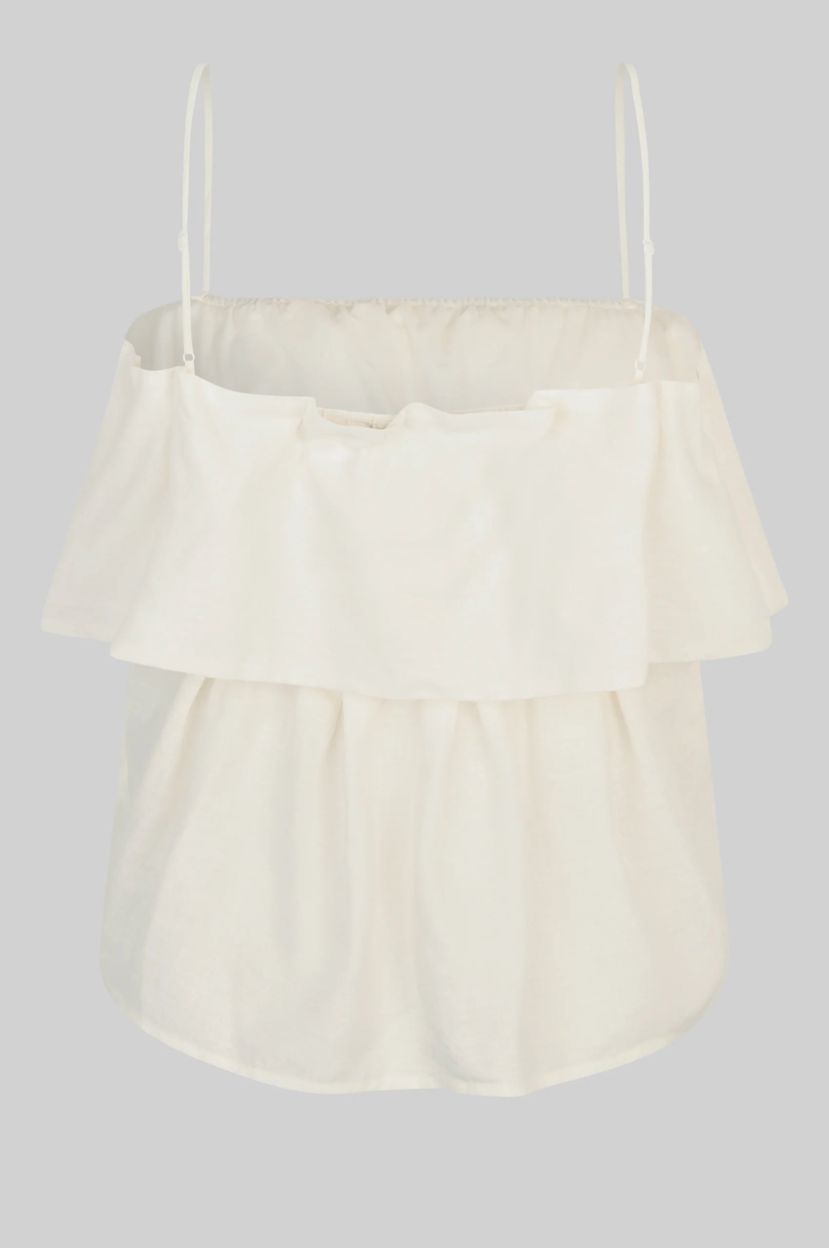 Cream-colored top with ruffled layers on a light gray background rear view