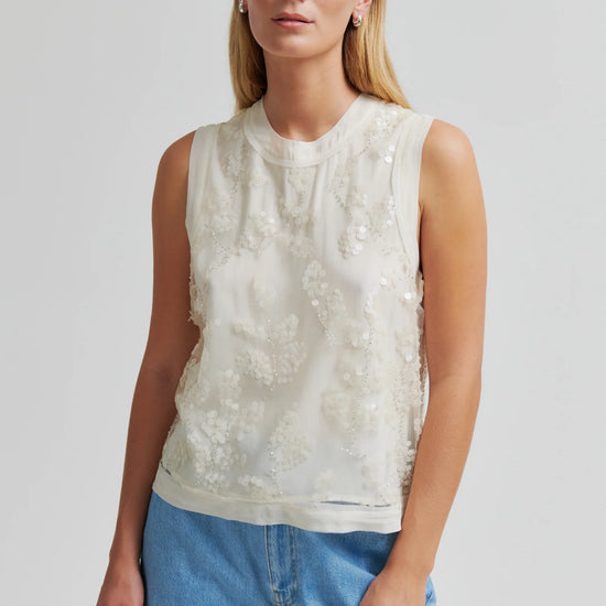 Cream sequin detail top worn with blue jeans