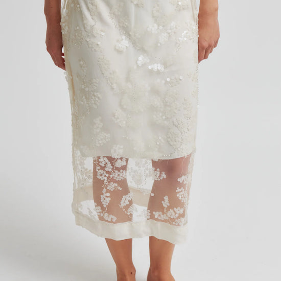 Person wearing a white lace skirt on a plain background from Second Female