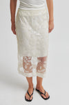 Person wearing a white lace skirt on a plain background from Second Female