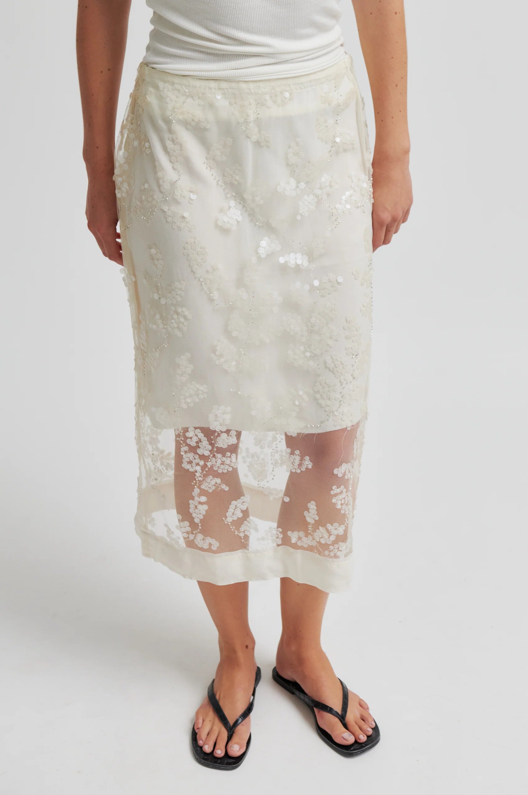 Person wearing a white lace skirt on a plain background from Second Female