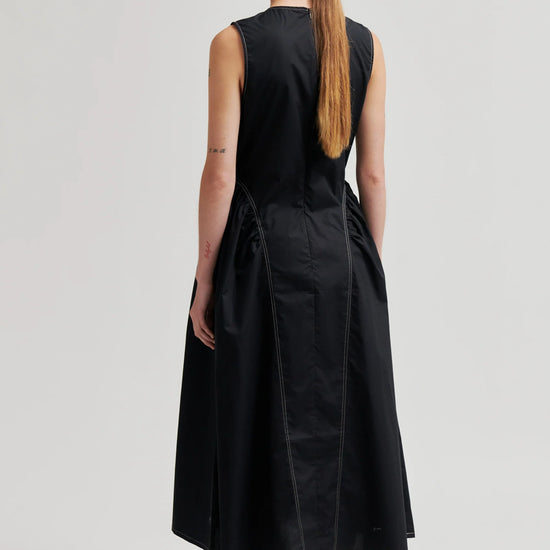 model wearing black structured dress from the rear 