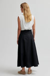 model wearing black skirt and white top facing away from camera