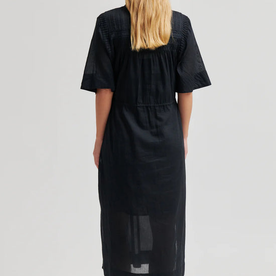 model wearing black dress from the rear 
