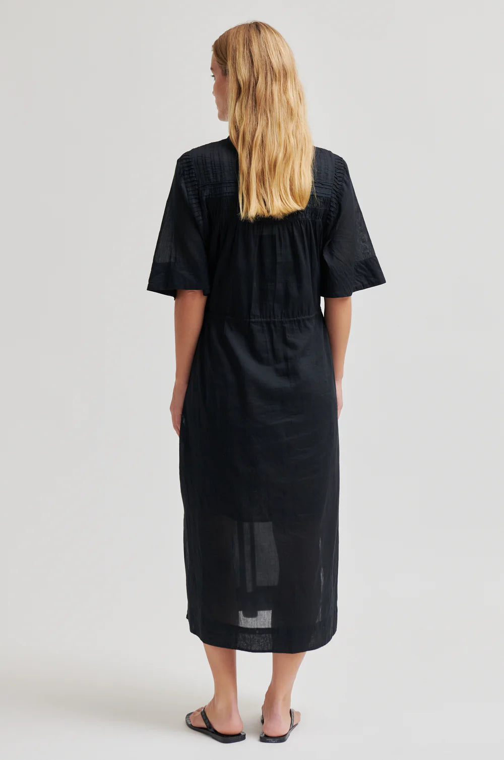 model wearing black dress from the rear 