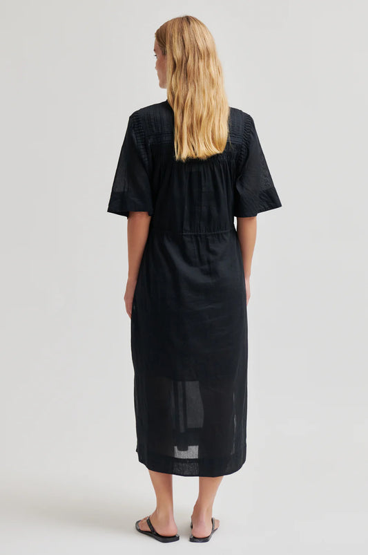 model wearing black dress from the rear 