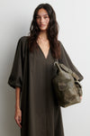 Woman wearing a dark green dress holding a matching backpack against a white background from Second Female