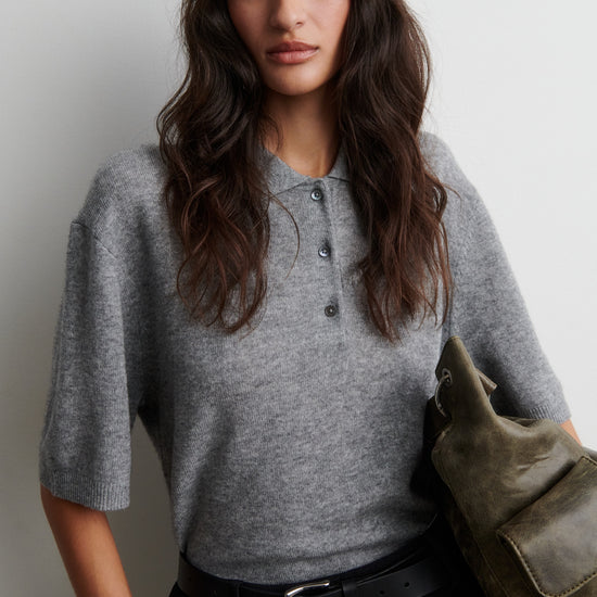 Woman wearing a gray cashmere blend sweater holding a green bag against a plain background from Second Female