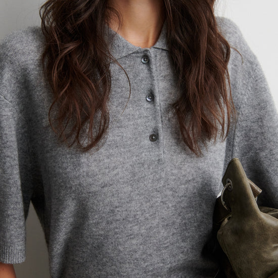 Person wearing a gray cashmere blend short sleeve sweater with a plain background from Second female
