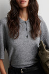 Person wearing a gray cashmere blend short sleeve sweater with a plain background from Second female