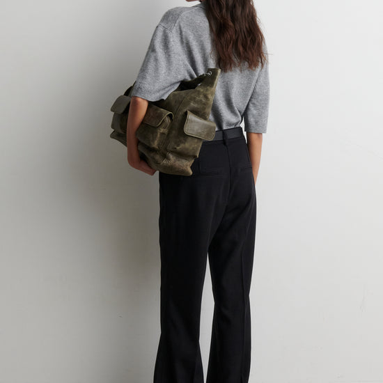 Person holding a green bag against a white background from second female