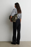Person holding a green bag against a white background from second female